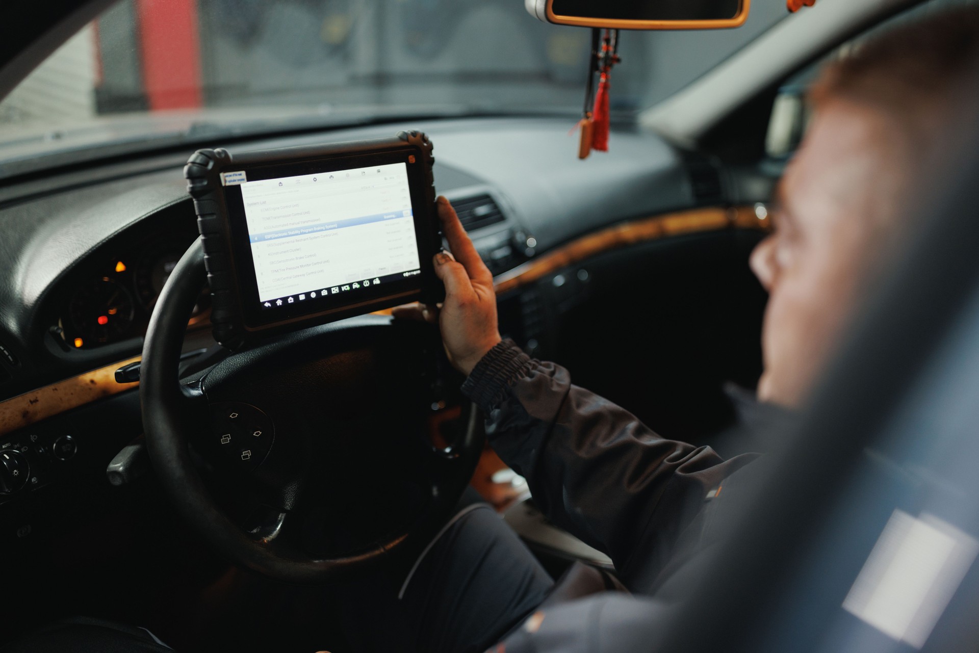 Auto Mechanic Running Diagnostics on Car Tablet